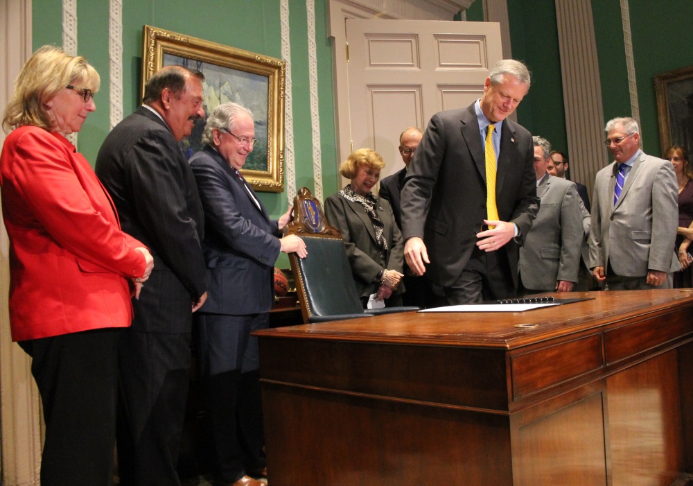 Gov. Charlie Baker sat down to sign the "grand bargain" bill Thursday. Photo: Sam Doran/SHNS