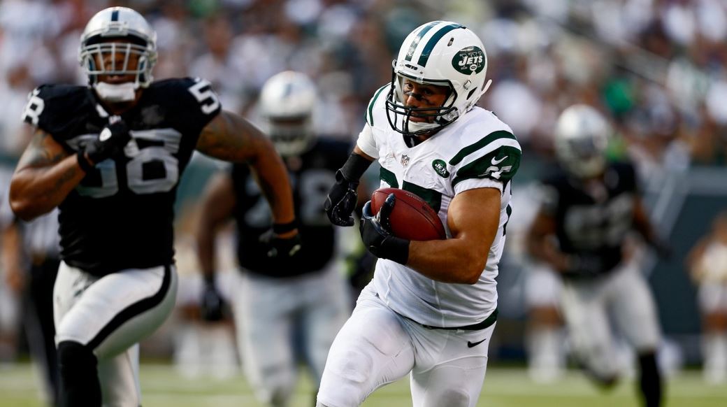 Eric Decker attempts to speed away from Oakland Raiders defenders. (Getty Images)
