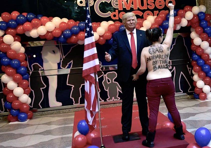 Bare-breasted FEMEN activist grabs Trump statue by crotch