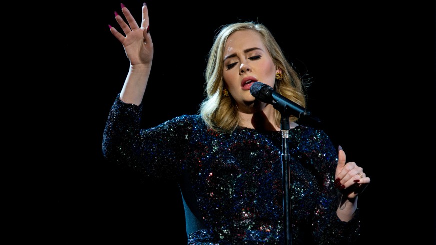 Adele singing with her hand in the air