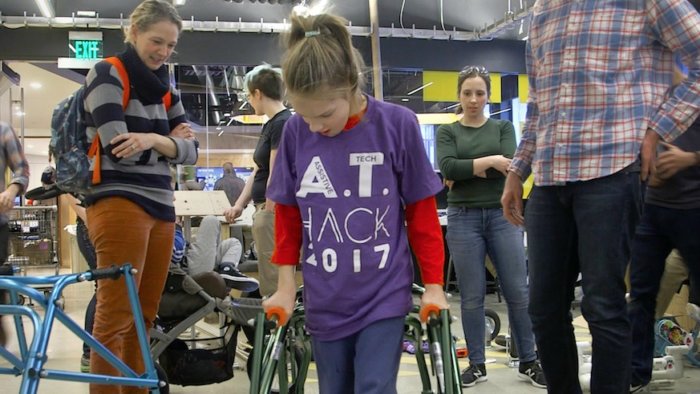 Lilly testing out her modified walker while her mother (left) looks on. Photo: John Friedah/MIT