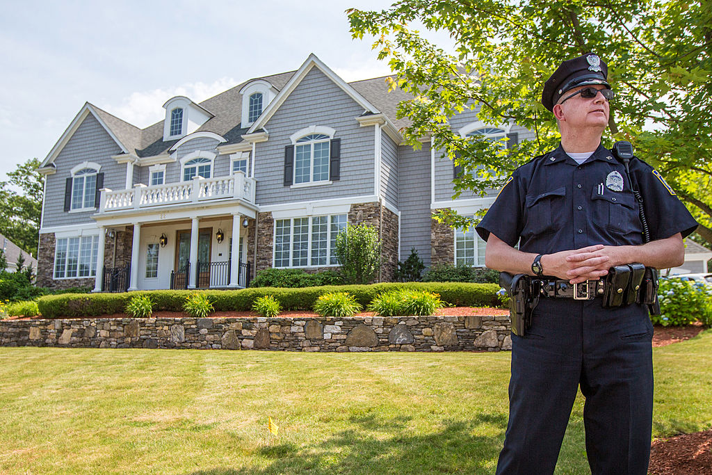 A local police officer stood outside the home of New England Patriots player Aaron Hernandez in North Attleboro in 2013 after Hernandez was linked to the murder investigation of Odin Lloyd.