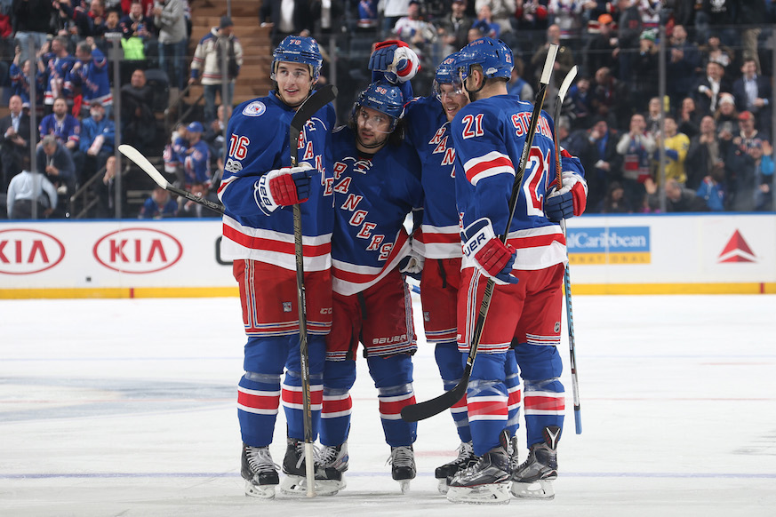 Members of the New York Rangers huddle together in celebration after scoring a goal. (Getty Images)