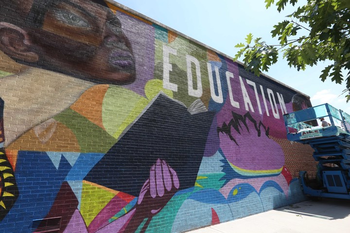 A mural on the back of P.S. 154 in Harlem depicts  women reading and the slogan "Education is not a crime."