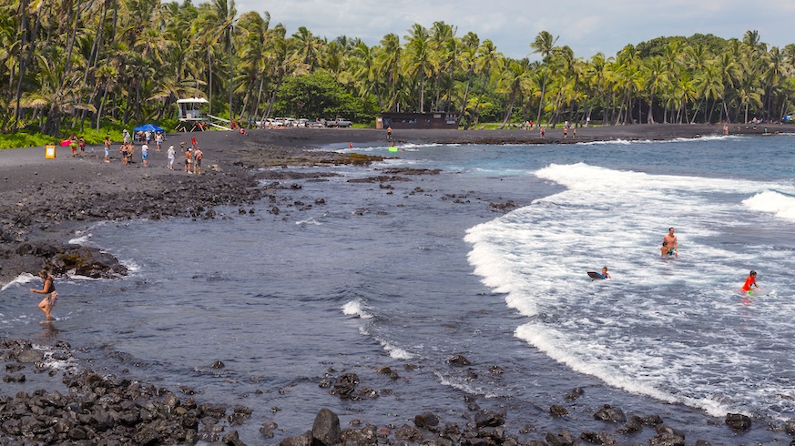 Surf or just relax on the unique black sand beaches of Punaluu. Credit: Getty Images