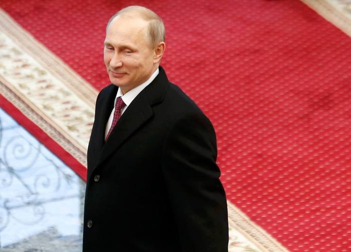 Russian President Vladimir Putin reacts after peace talks on resolving the Ukrainian crisis in Minsk, February 12, 2015