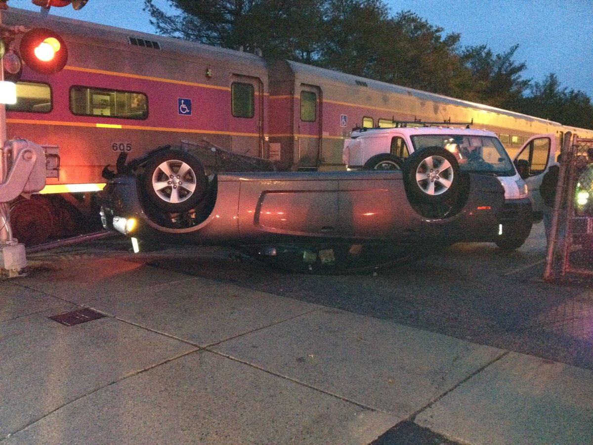 Needham commuter rail train upends car parked next to tracks