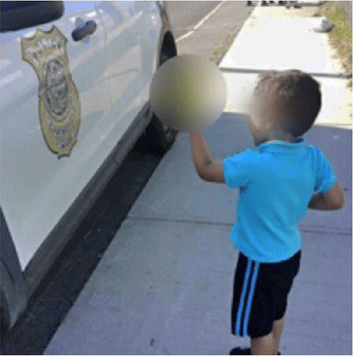 Photo of young boy giving finger to police cruiser goes viral