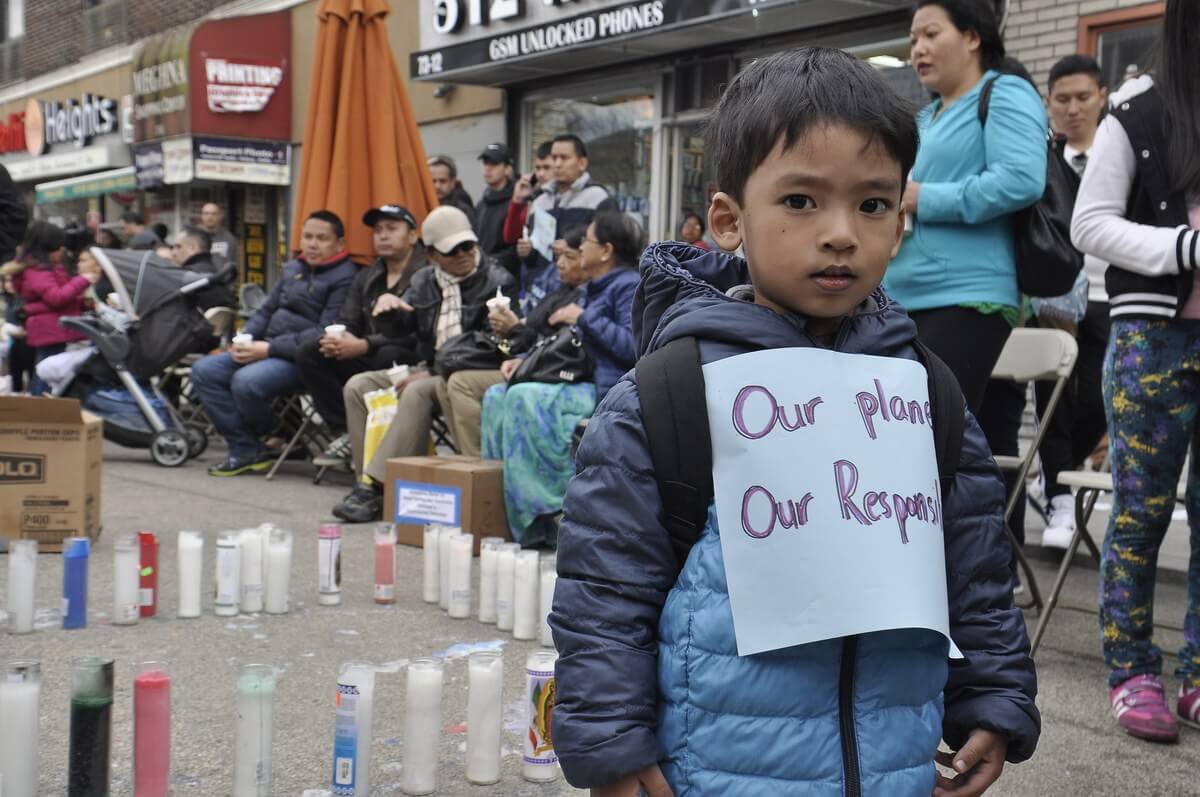 A child is seen with a sign in remembrance of the victims of the earthquake in Nepal.