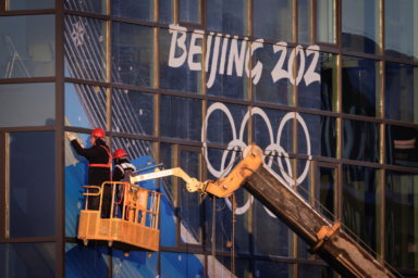 Workers attach signage near Big Air Shougang, a competition venue for the Beijing 2022 Winter Olympics in Beijing