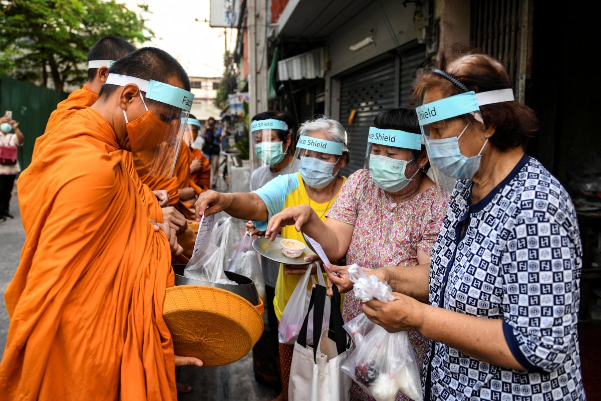 Buddhist monks wearing face shields and mask to protect themselves