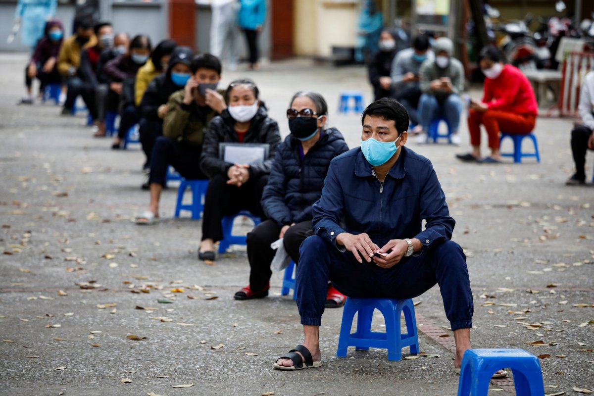 Residents wearing protective masks wait for coronavirus testing at a
