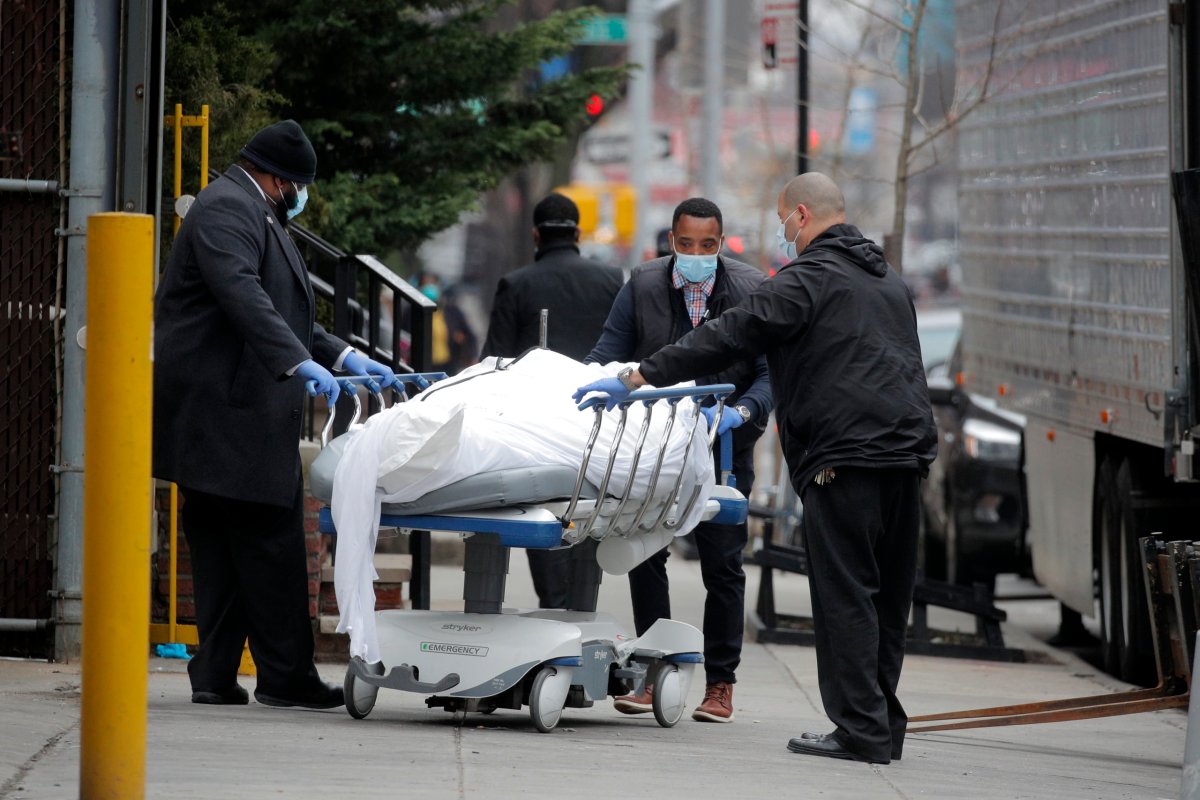 Workers wheel a deceased person outside of Brooklyn Hospital Center