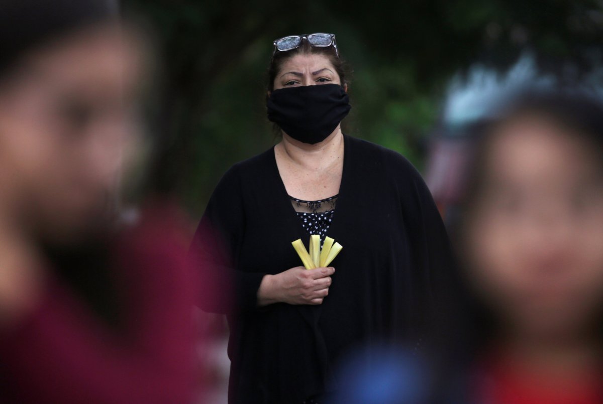 A woman holds a palm during a procession of the