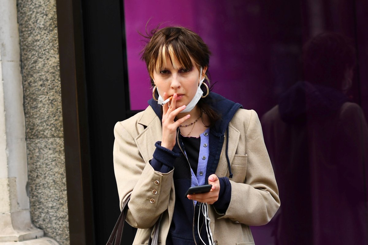 FILE PHOTO: A woman smokes a cigarette while wearing a