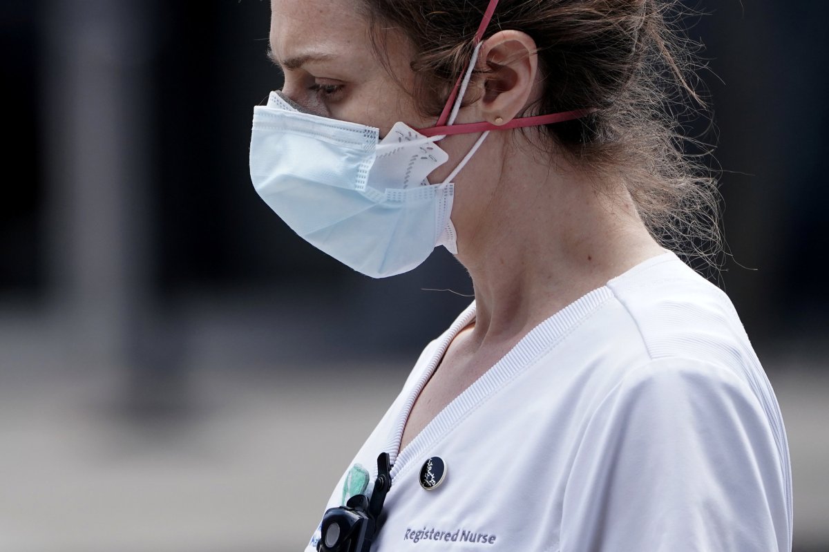 A registered nurse walks out of a hospital during the