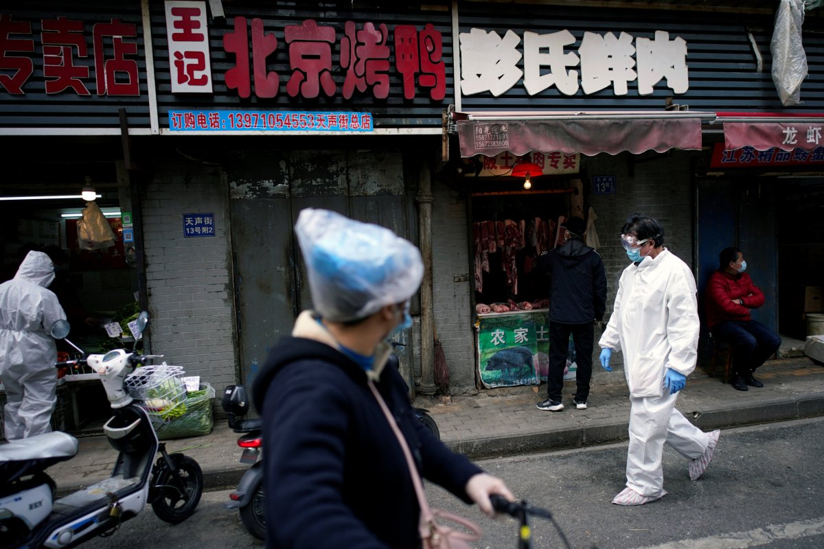 People wearing protective suits is seen at a street market