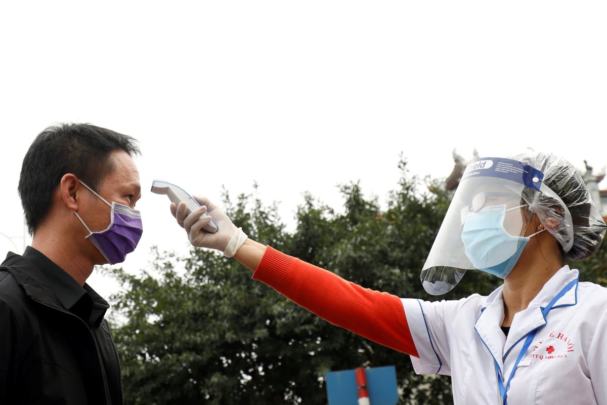 A health worker wears a protective face shield as she