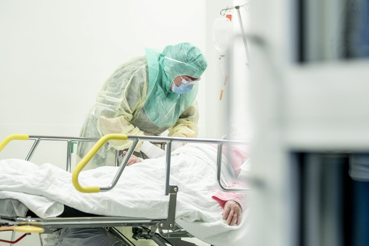 A nurse in protective gear takes a blood sample of