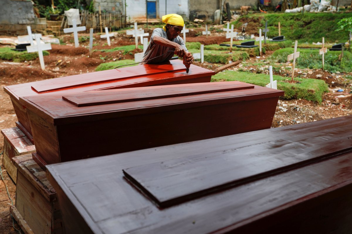 Suherman, a 45-year-old coffin maker, prepares coffins ordered to be