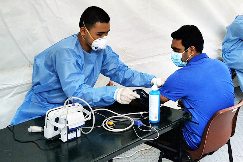An Academy of Medicine staff attends to a migrant worker