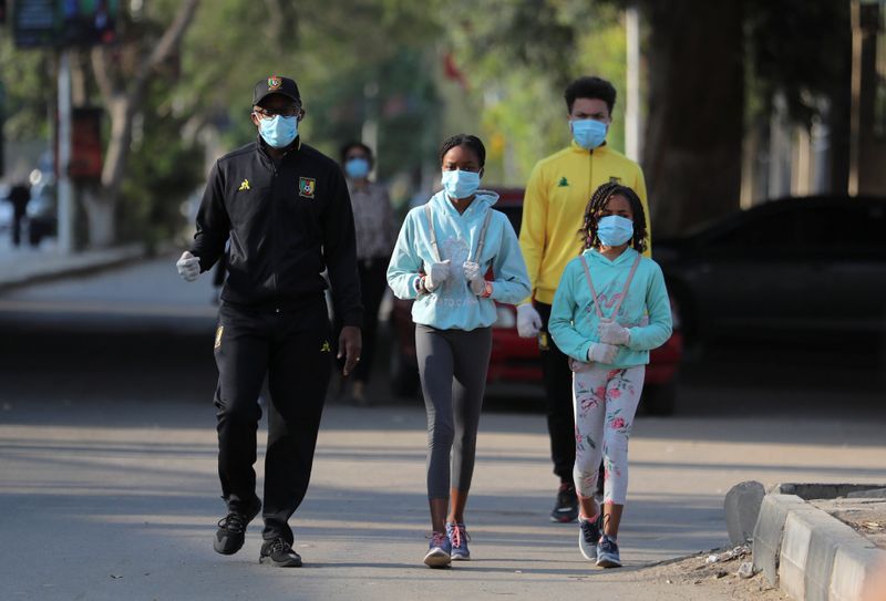 A family takes a walk while wearing face masks in