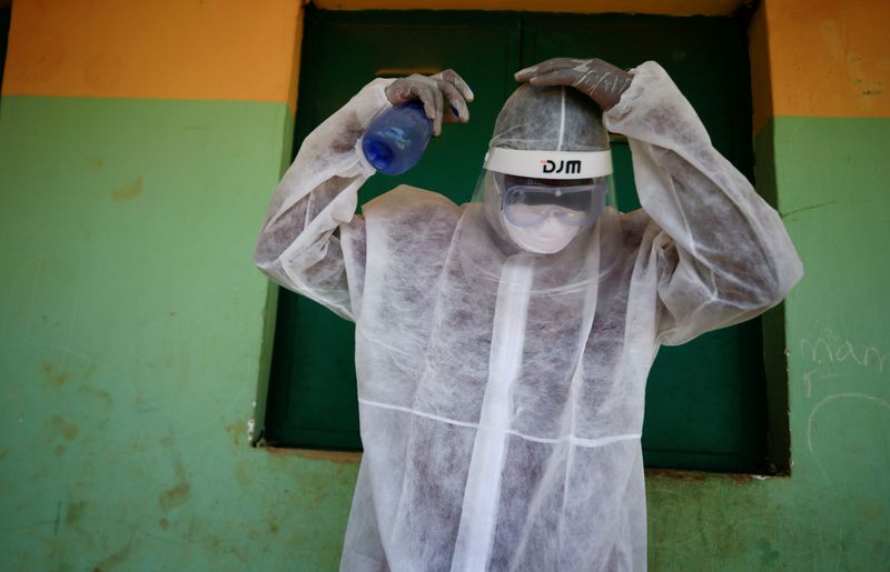 FILE PHOTO: A health worker sprays his headset during a