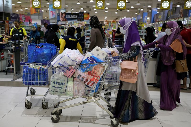 FILE PHOTO: People wearing protective masks shop at a supermarket