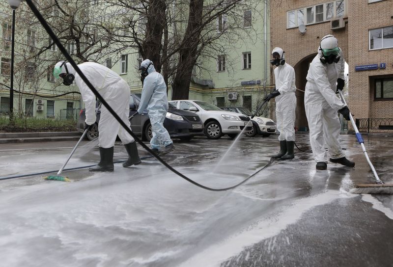 FILE PHOTO:  Specialists spray disinfectant while sanitizing a street