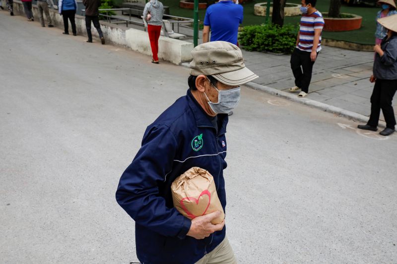 A man holds a rice bag after getting rice from