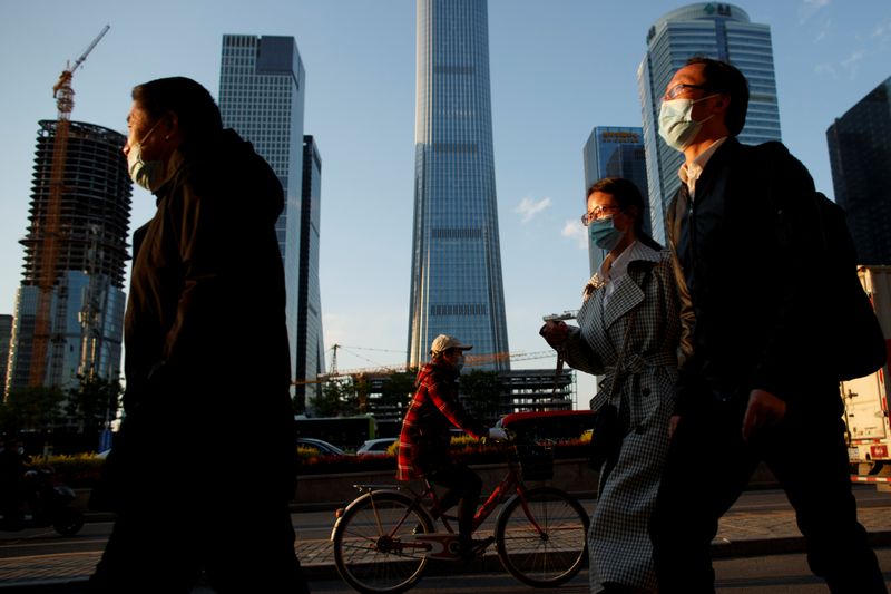 People wear protective masks as they leave work during evening