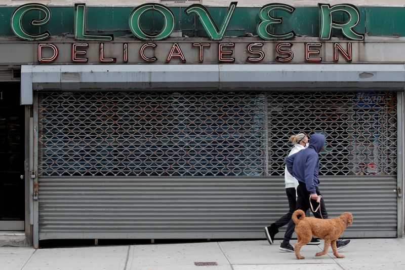 People pass by a closed Clover Delicatessen, during the outbreak