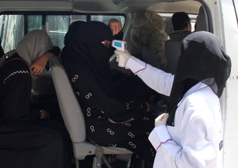 FILE PHOTO: A health worker takes temperature of passengers of