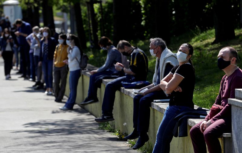 FILE PHOTO: People keep social distance while waiting in line