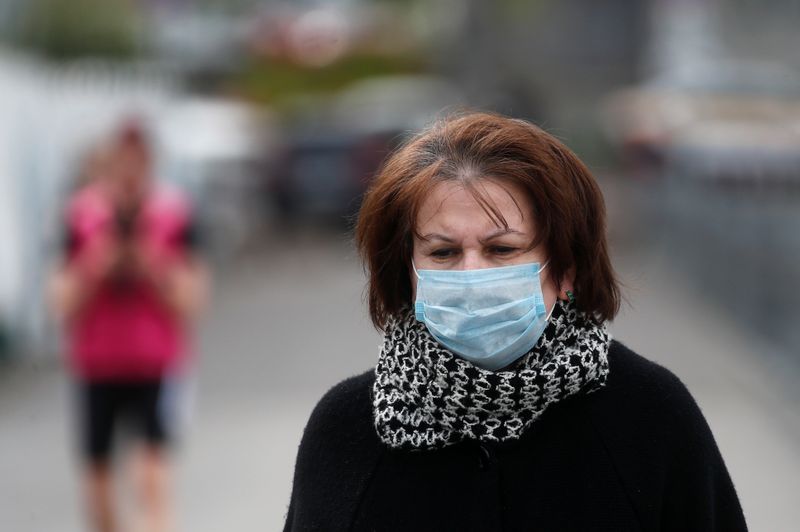 A woman wearing a protective face mask walks outside Moscow