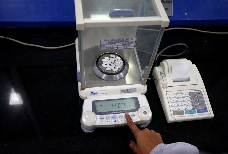 A pharmacist checks weight of Paracetamol tablets inside a lab