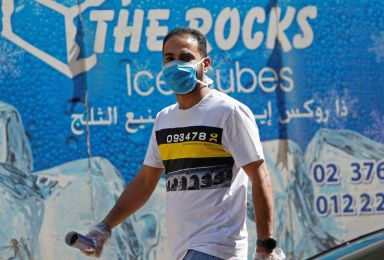 A man wearing a protective face mask walks in Cairo