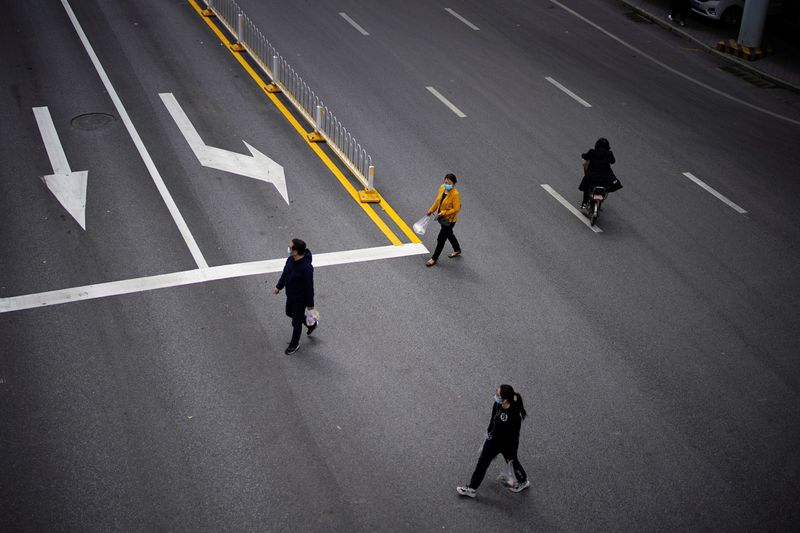 People wearing face masks cross a road in Wuhan