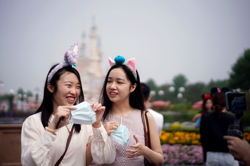 Visitors hold face masks at the Shanghai Disneyland
