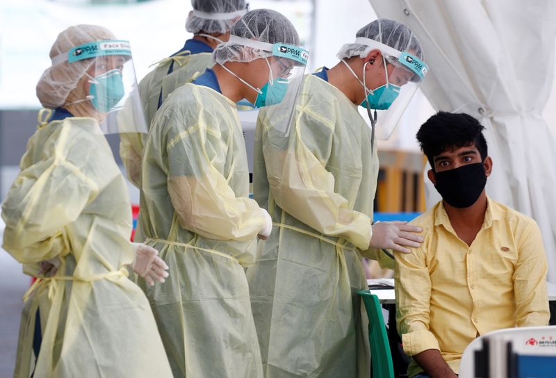Medical workers prepare to perform a nose swab on a