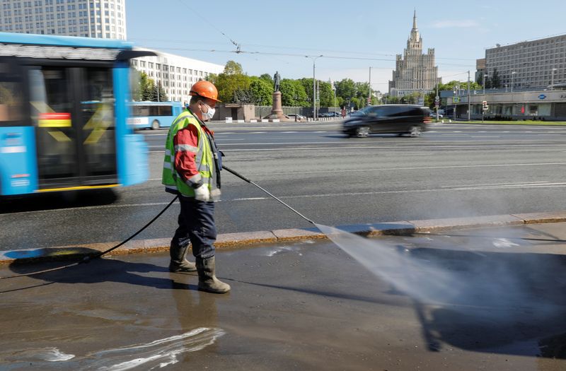 A specialist sprays disinfectant while sanitizing a bridge amid the