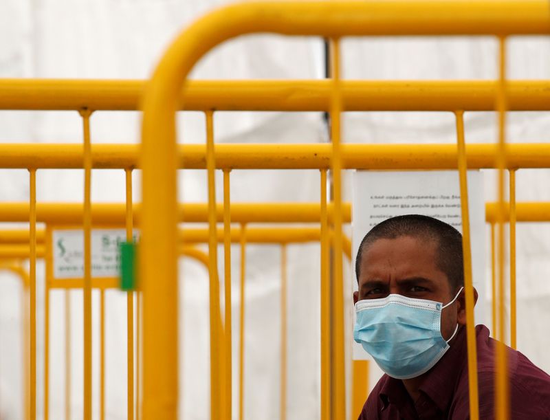 A migrant worker looks on from a swab isolation facility