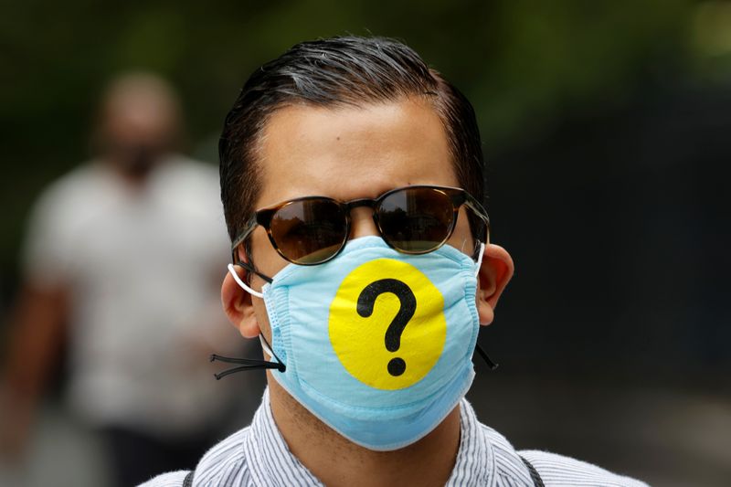 Man wears a protective face mask decorated with a question