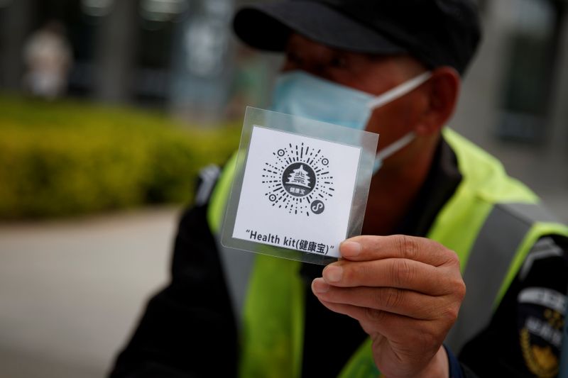 Security guard holds up a QR code for a health