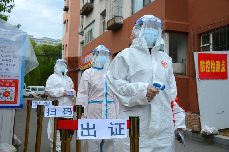 Volunteers in protective suits are seen a checkpoint following the