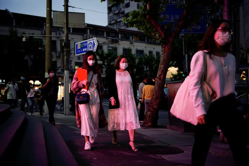 People wearing face masks are seen on a street following