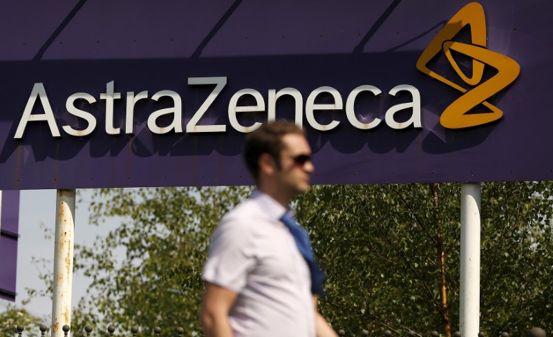 A man walks past a sign at an AstraZeneca site