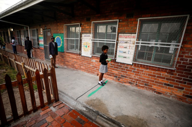 FILE PHOTO: Learners observe social distancing markers as they queue