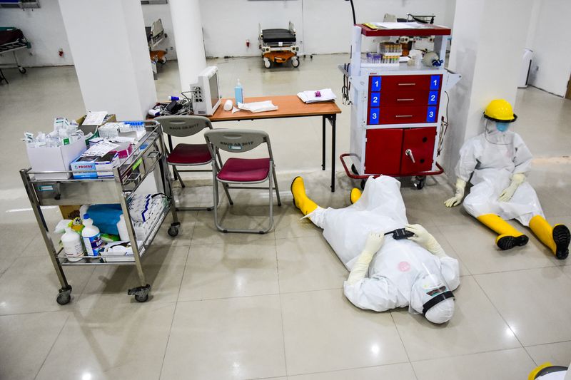 FILE PHOTO: Medical staff wearing protective suits take a rest
