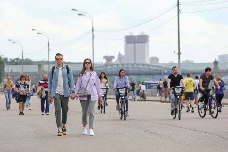 People walk and ride bicycles in Moscow